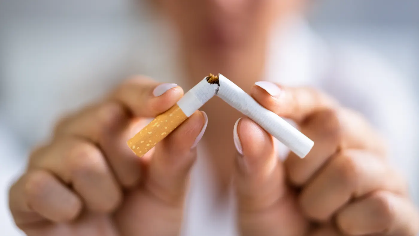 Mains cassant une cigarette en deux, symbole de l'arrêt du tabac
